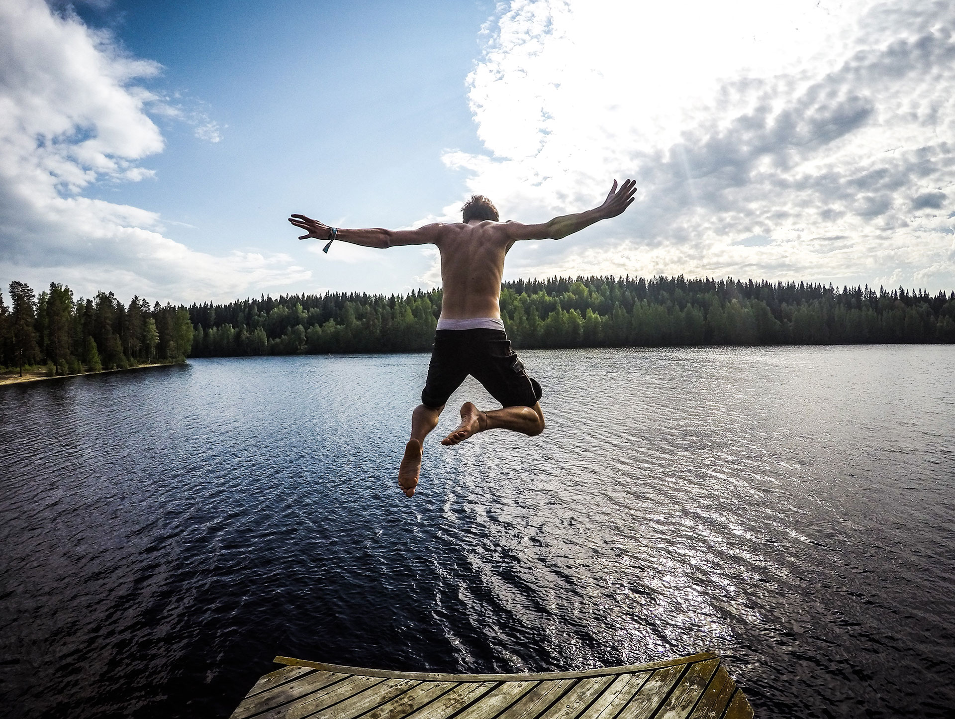 man leaping, soaring like a bird into water
